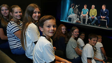 Kinder sitzen im 3D-Kino und freuen sich auf den Film